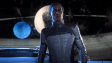 a man standing in front of a blue planet
