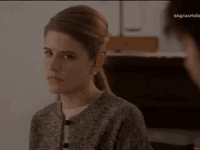 a woman is sitting in a chair and looking at a man in a room .