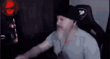 a man with a beard is sitting in a gaming chair .
