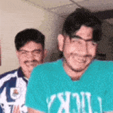two men are sitting next to each other and smiling .
