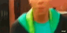a blurry picture of a person with a green scarf around their neck ..