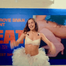 a woman in a white dress is dancing in front of a sign that says roye swan