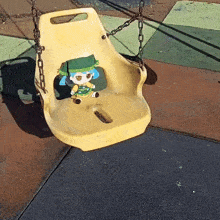 a yellow swing with a stuffed doll on it