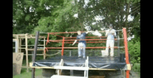 two men are standing in a boxing ring with a sign that says ' g ' on it