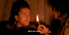 a man lighting a match with the words we 're on a boat