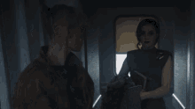 a man and a woman are standing in a dark room