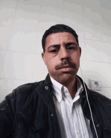 a man with a mustache wearing a black jacket
