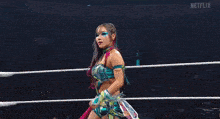 a woman is standing in a wrestling ring with a sign that says ' raw ' on it