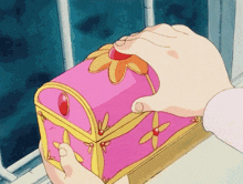 a person holding a pink box with a flower on it