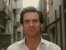 a man is standing in a narrow alleyway looking at the camera .