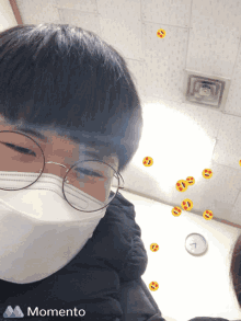 a boy wearing glasses and a face mask has a momento sticker on his face