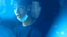 a man wearing a mask and headphones is looking at something in a dark room .