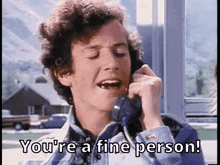 a man is talking on a telephone and saying you 're a fine person .