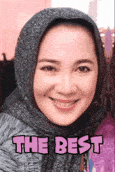 a woman wearing a hijab is smiling with the words " the best " on the bottom