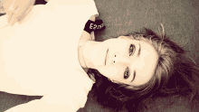 a woman wearing a white shirt with a black band around her neck that says e2a2v on it