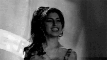 a woman in a black and white photo is smiling and looking at the camera .