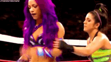 a woman with purple hair is standing in a wrestling ring .