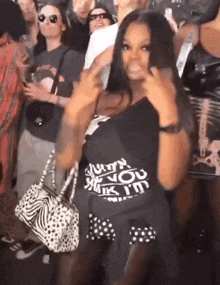 a woman wearing a black shirt that says just you while holding a zebra print purse