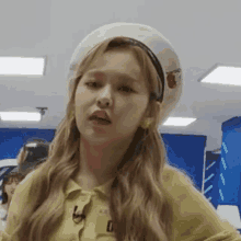 a close up of a woman wearing a beret and a yellow shirt .