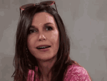 a woman wearing sunglasses looks at the camera