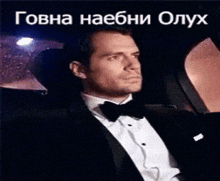 a man in a tuxedo is sitting in the back seat of a car