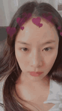 a close up of a woman 's face with hearts on her head
