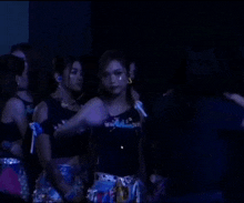 a group of women are standing in a dark room and the words hi chat are on the screen