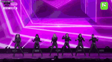 a group of women are dancing on a stage .