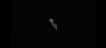 a sniper rifle with a scope is floating in the air in the dark .