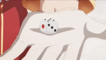 a person is holding a white dice in their hand with a red circle on it .