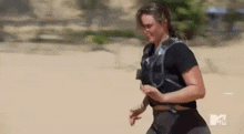 a woman is running on a sandy beach in the desert .