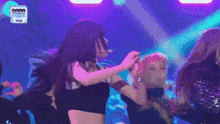 a group of women are dancing on a stage in front of a visa logo .