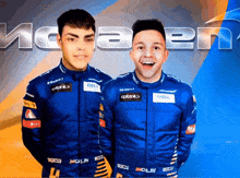 two men are posing for a picture in front of the word mclaren