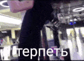 a person is standing in a gym with the word tepete written on the bottom of the screen .