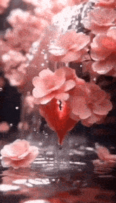 a vase filled with pink flowers and a red heart in the middle of it .