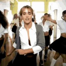 a woman is dancing in front of a group of people in a room .