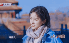 a woman wearing a scarf and a blue jacket with chinese writing
