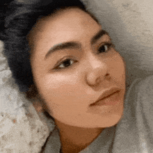 a close up of a woman 's face while laying in bed .