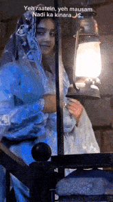 a woman holding a lantern with the words yeh raatein yeh mausam nad ka kinara