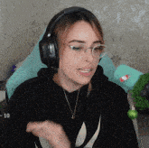 a woman wearing headphones and glasses is sitting in front of a christmas tree