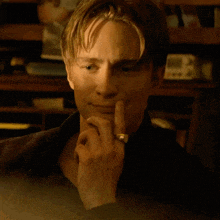 a man with a ring on his finger is looking at something