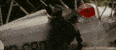 a man is standing next to a plane with the letters cbn on it