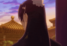 a woman with long hair is standing in front of a building with a purple sky in the background .