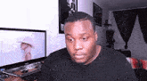 a man is sitting in front of a computer monitor .