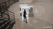 a woman is standing in a dining area with stairs in the background