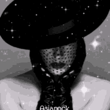 a black and white photo of a woman wearing a hat and gloves with asiarock written on the bottom