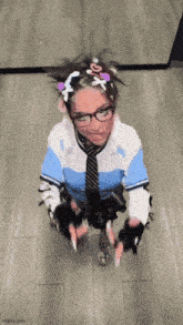 a woman wearing glasses and a tie is kneeling down on the floor .