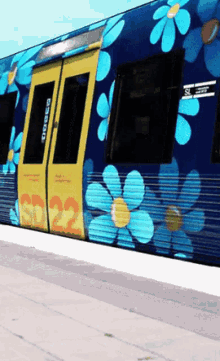 a blue train has flowers painted on the side and the number 22 on the door