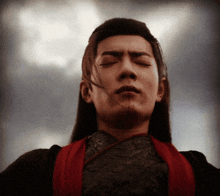 a man with long hair has his eyes closed
