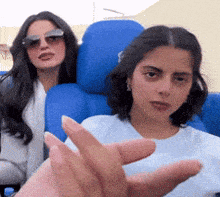 a woman wearing sunglasses is sitting next to another woman wearing sunglasses